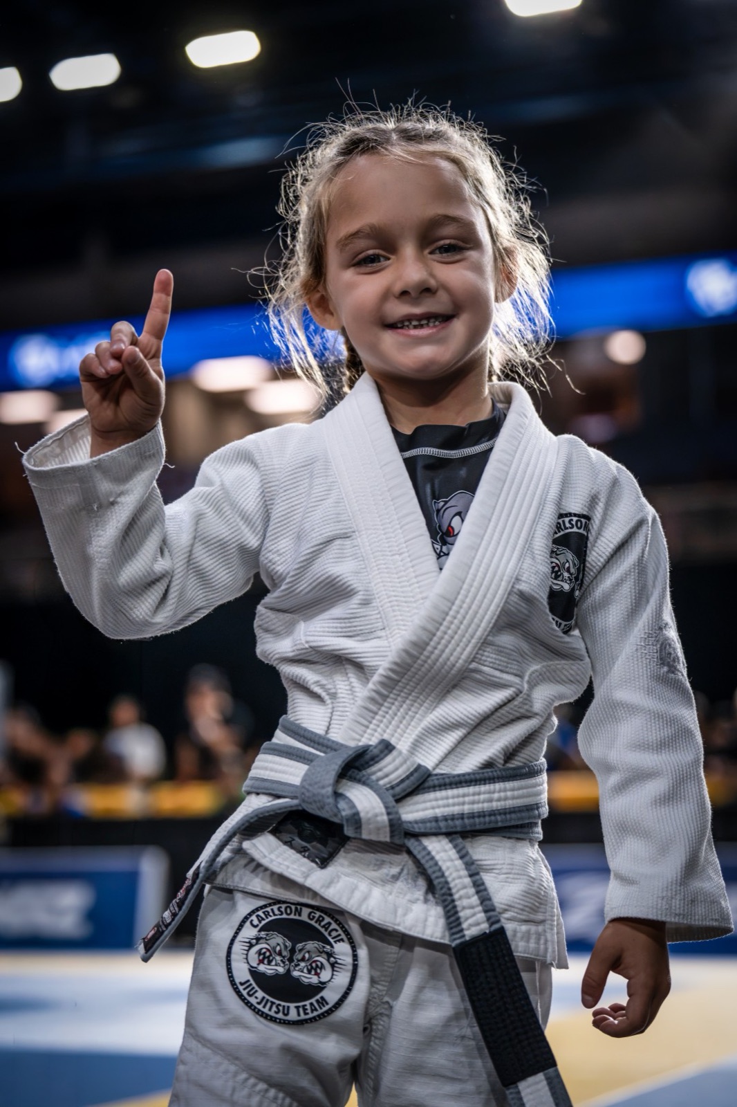 A young Carlson Gracie student in her gi after a win