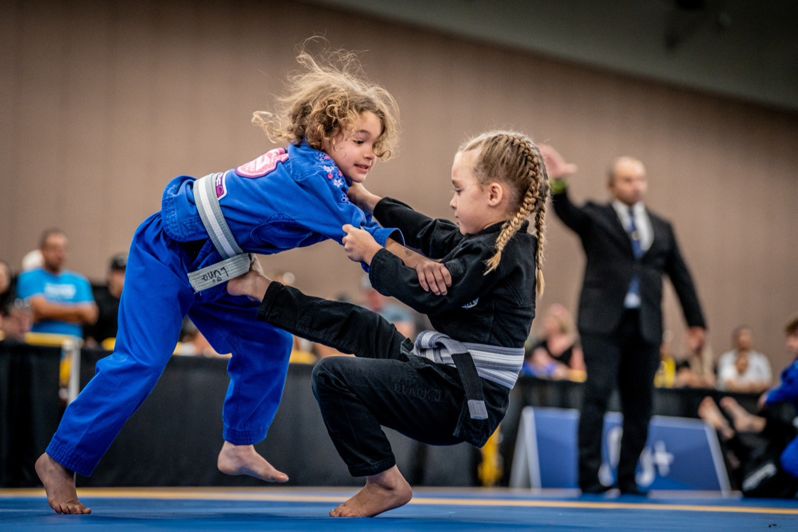 Two young competitors gripping up at an IBJJF tournament